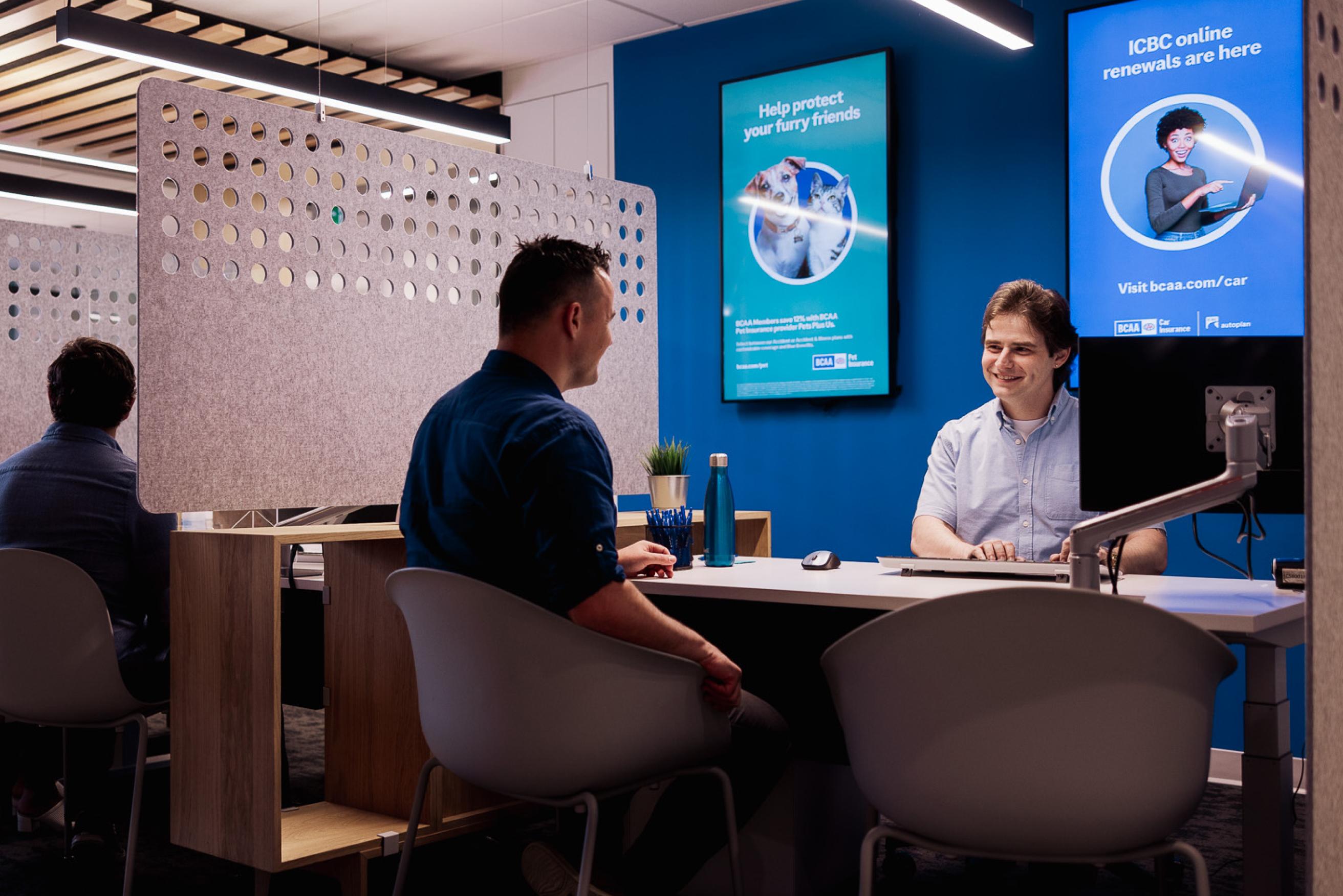 A person sitting at the desk of a BCAA insurance employee.