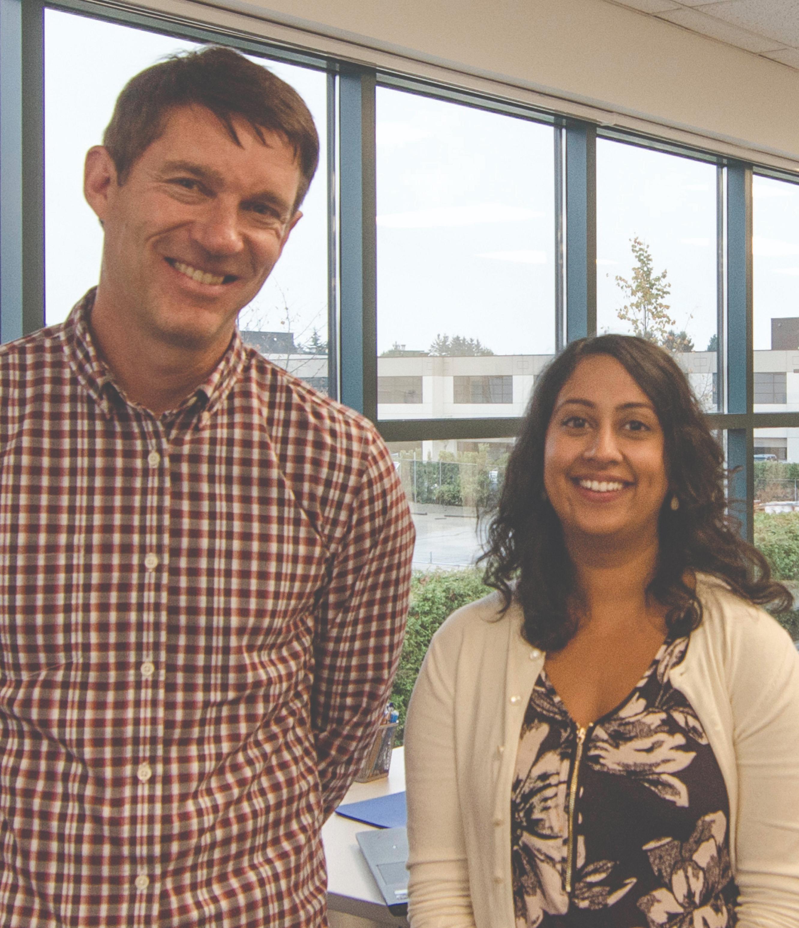 Man and a woman smiling at the camera.
