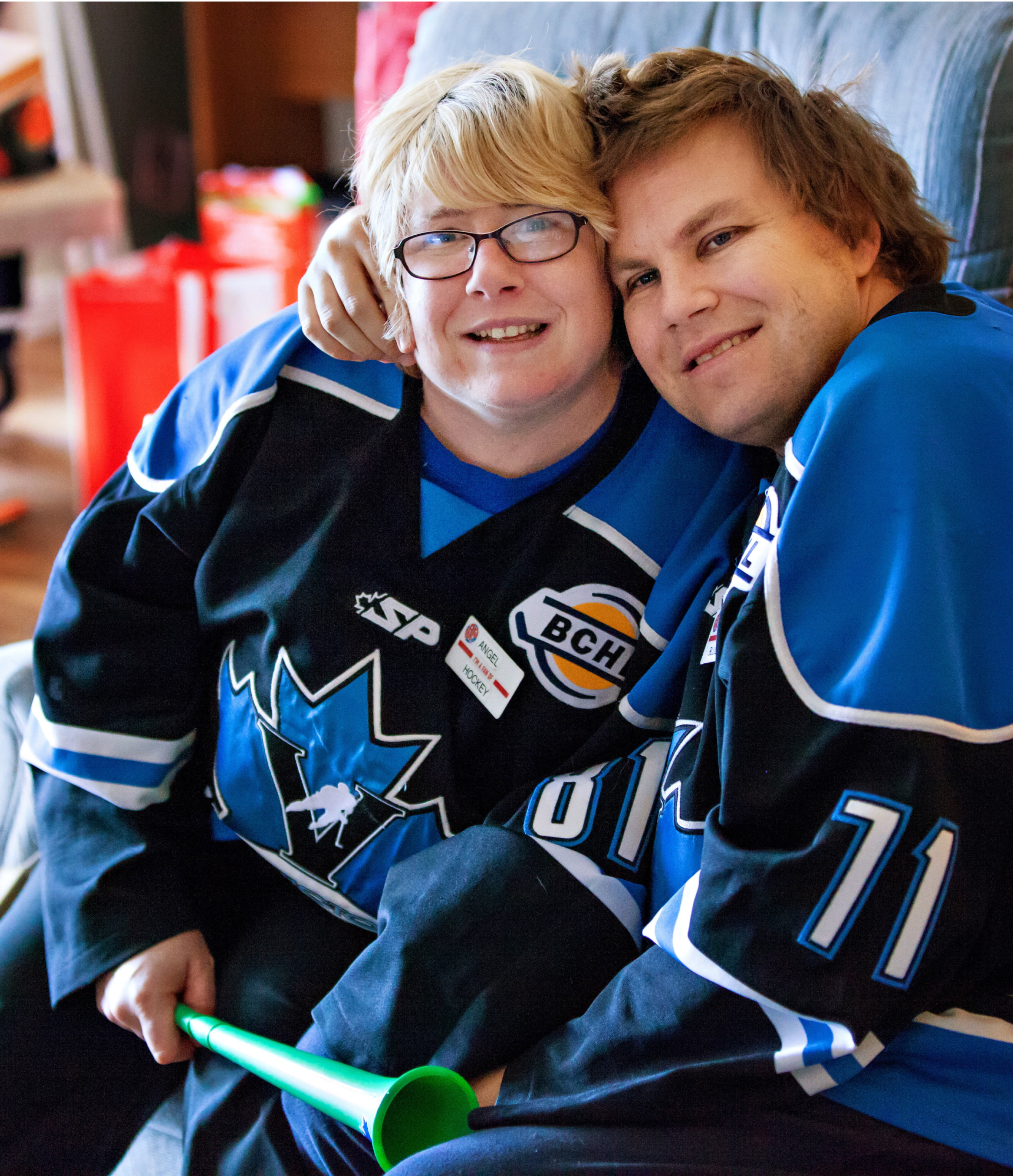 Two people in hickey uniforms embracing and looking at the camera