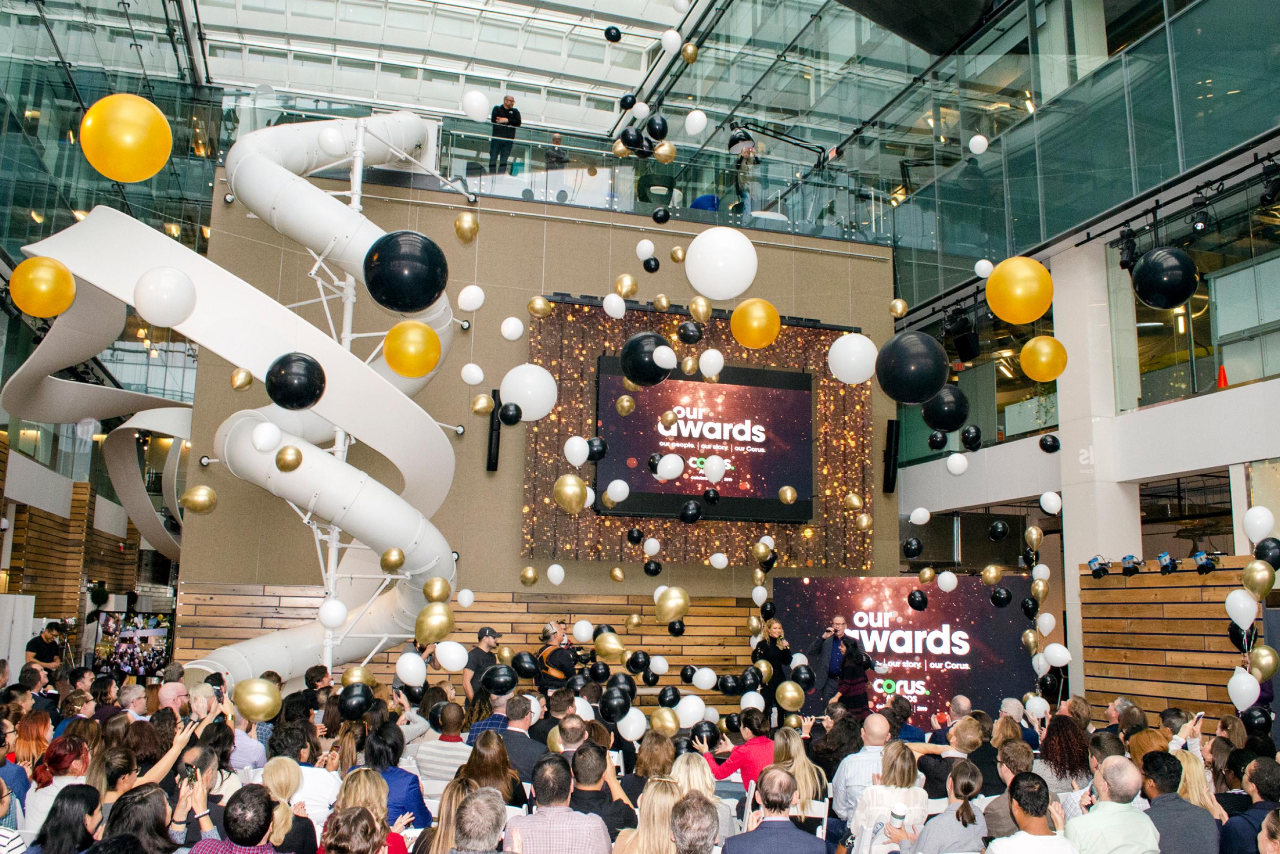 Photo of the inside of the Corus main lobby where many people are gathered to celebrate.