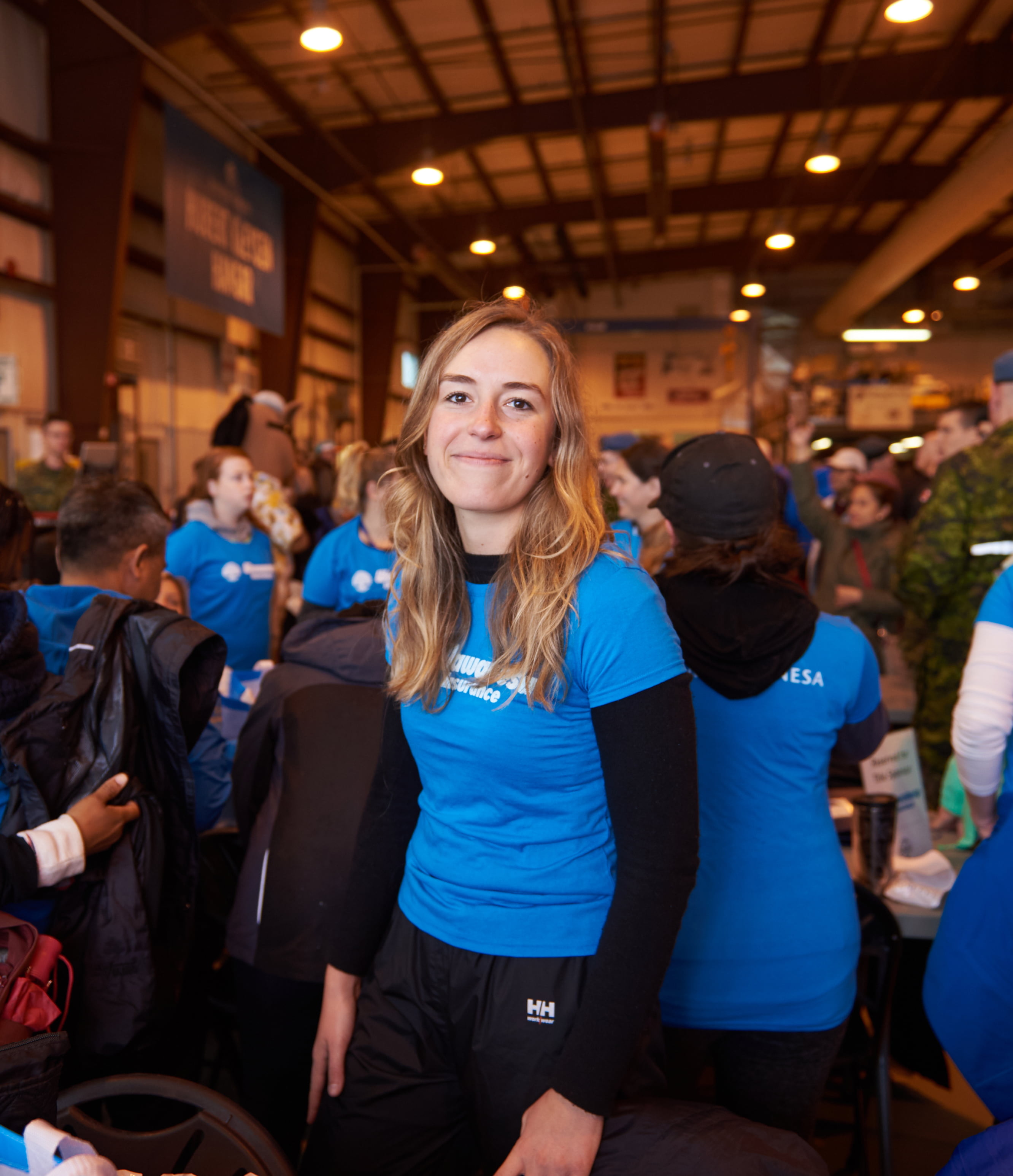 A woman smiling at the camera, wearing a blue Wawanesa volunteer shirt.